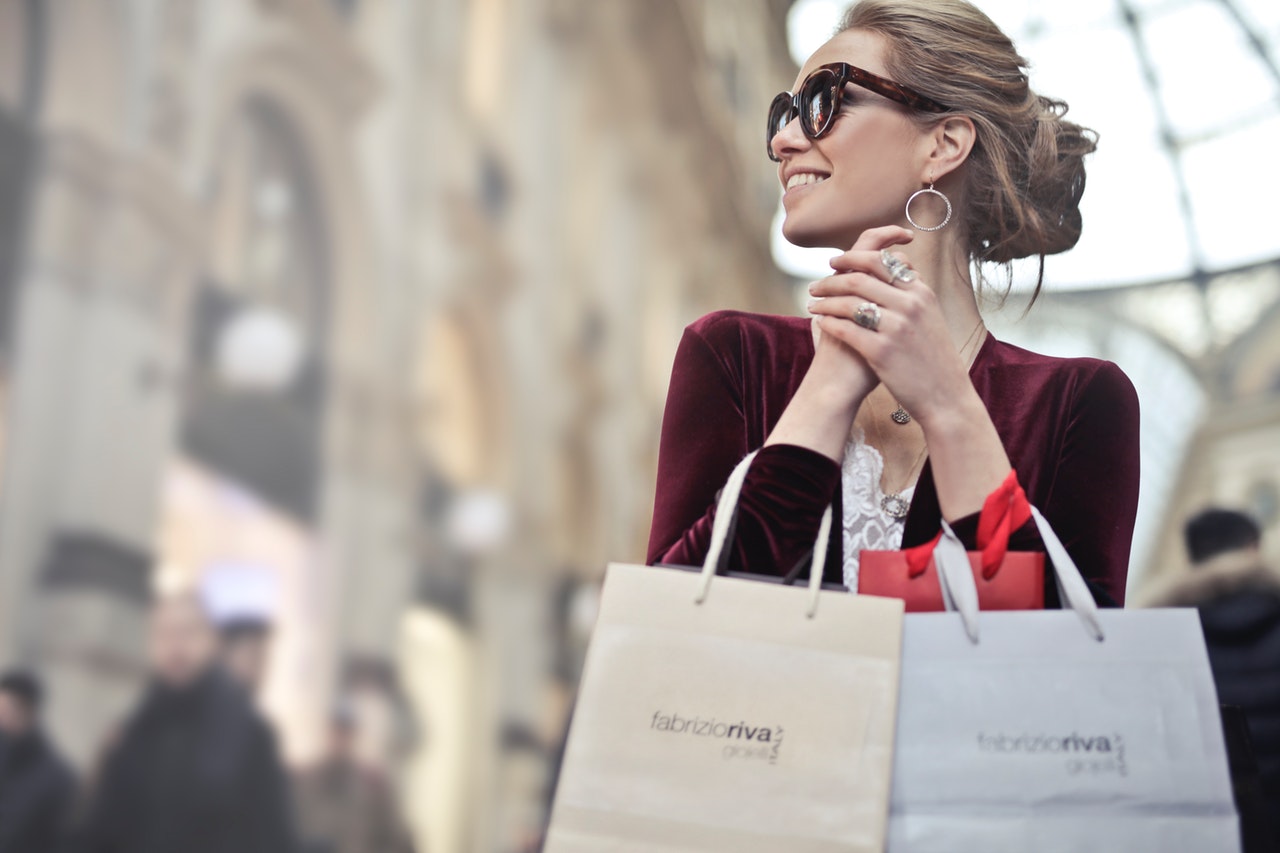 woman-holding-two-white-and-beige-shopping-paper-bags-in-974911